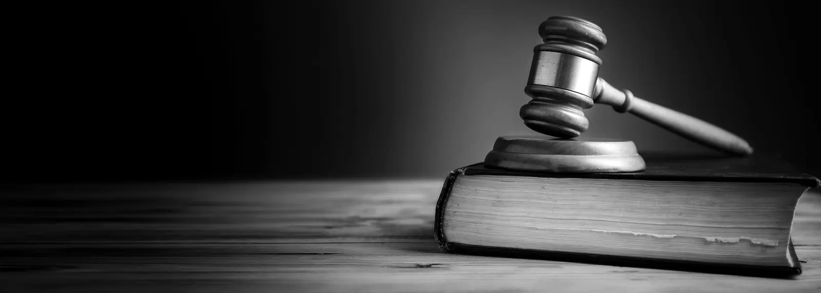 Richterhammer und Gesetzbuch auf einer Holzoberfläche